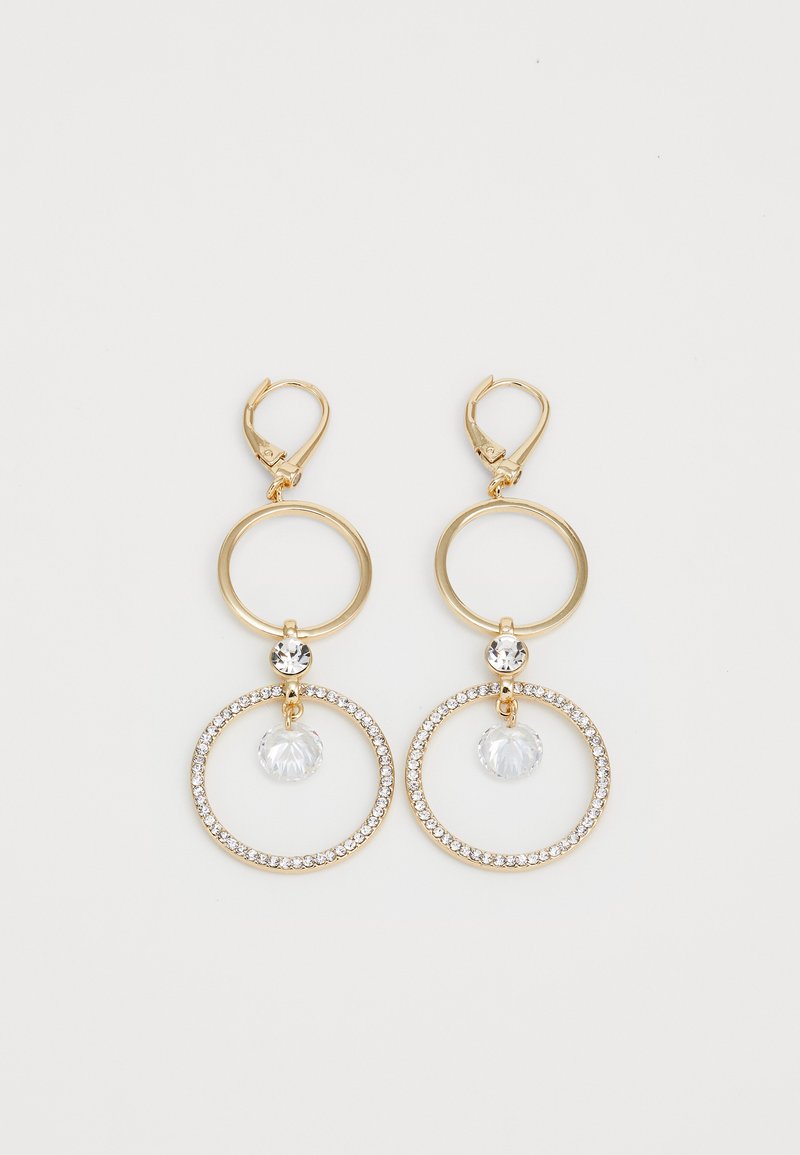 Boucles d'oreilles dorées avec des anneaux circulaires, présentant un pendentif en cristal transparent et un bord de petites pierres claires. Fermeture à levier.