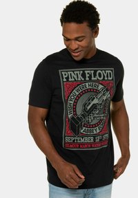 Sort t-shirt med et farverigt grafisk motiv af en mikrofon og teksten "PINK FLOYD WISH YOU WERE HERE ABERY ROAD" på fronten. Korte ærmer.
