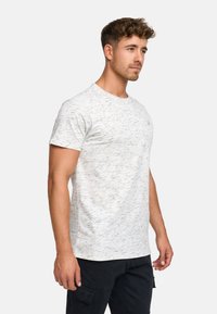 Hellgraues Kurzarm-T-Shirt mit einem strukturierten, gesprenkelten Muster. Runder Hals, aus weichem Stoff, getragen mit dunklen Cargo-Hosen.