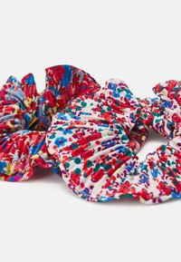 Dois elásticos de cabelo em tecido com padrões vibrantes. Um apresenta flores em vermelho e azul sobre uma base branca, enquanto o outro exibe desenhos abstratos multicoloridos.