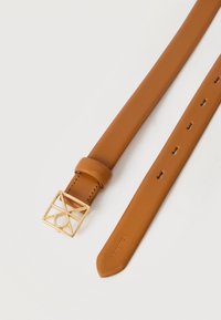 Καφέ δερμάτινη ζώνη με χρυσή γεωμετρική αγκράφα σε σχήμα τετραγώνου και πολλαπλές τρύπες ρύθμισης σε λευκό φόντο.