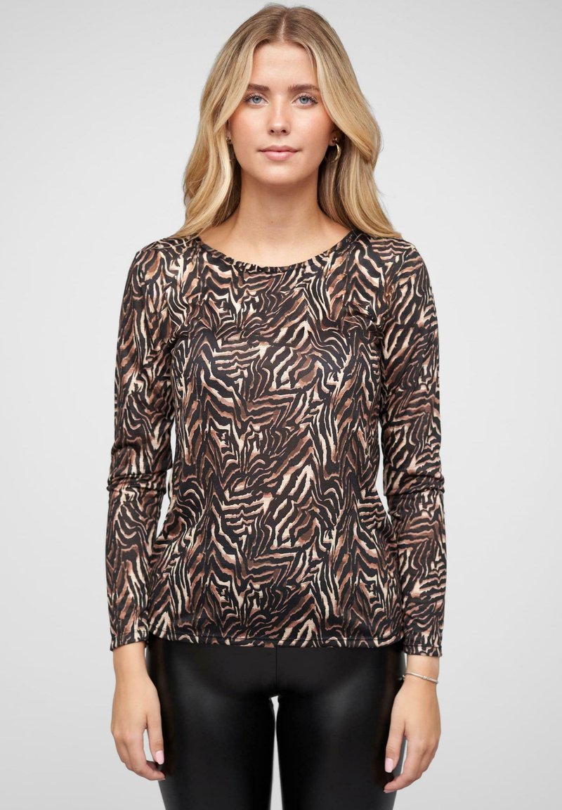 Langermet topp med et svart og brunt zebra mønster, med rund halslinning og mykt stoff. Sammen med sorte leggings.