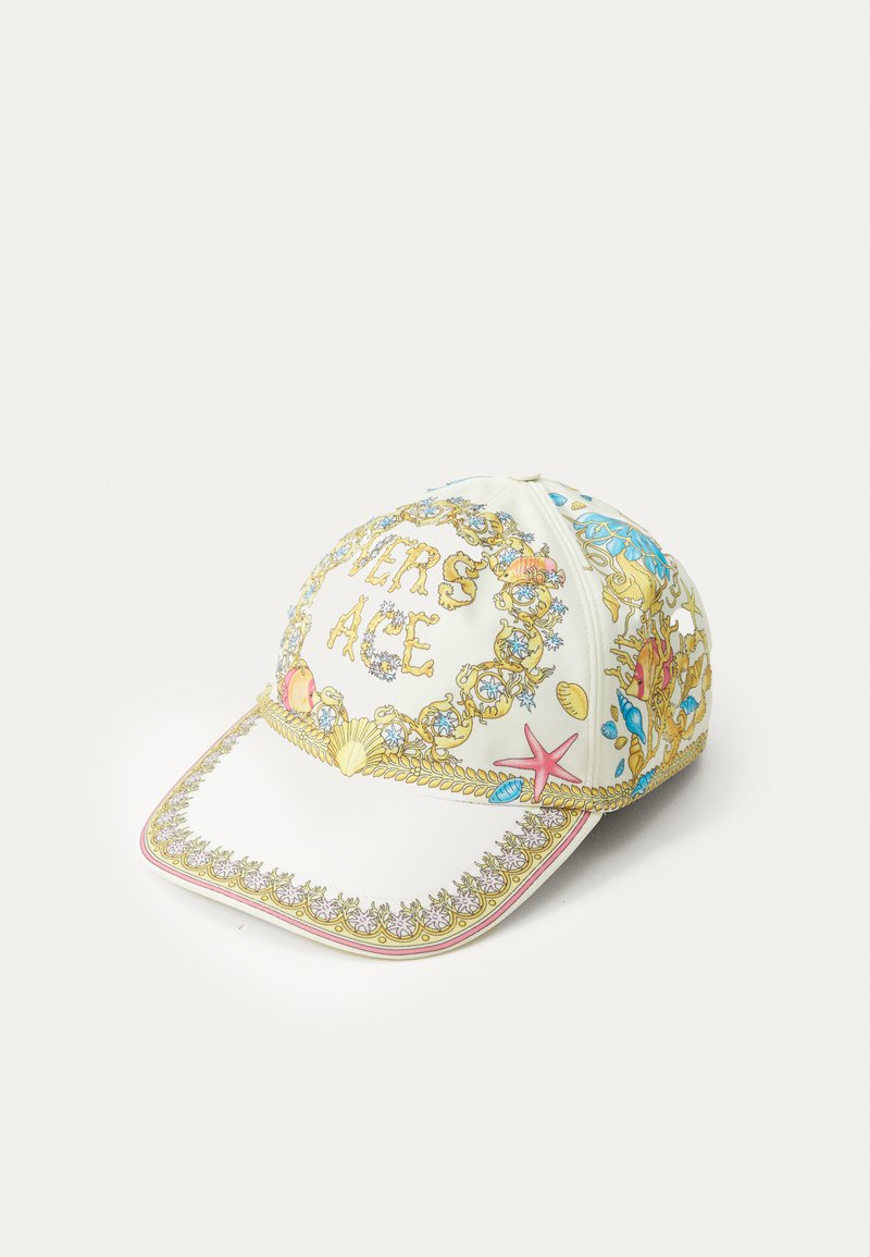 Wit pet met intrigerende multikleurige zee-thema prints, inclusief schelpen en zee sterren. Decoratieve gouden randen en een roze accent op de rand.