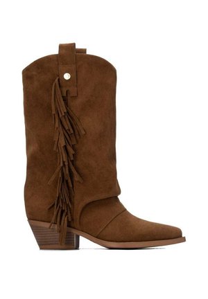 Bota de vaquero de ante marrón con detalle de flecos en el lateral, tacón bajo apilado y una lengüeta en la parte superior.