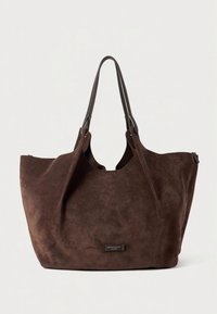 Geantă tote din piele întoarsă maro, cu un interior spațios, partea superioară deschisă curbată și două bretele din piele. Are o etichetă cu brandul pe partea din față.