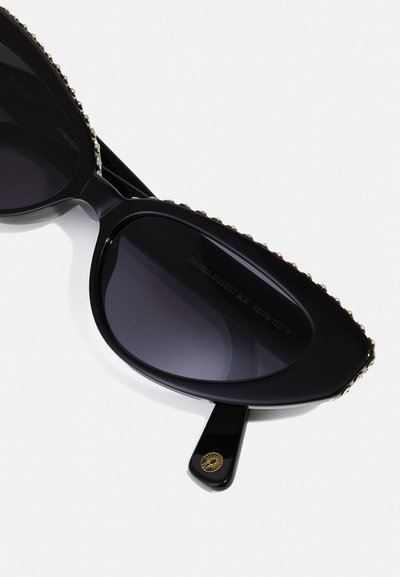 Black sunglasses with a cat-eye shape, dark lenses, and a decorative gold studded trim on the edges. Features a branded arm with logo.