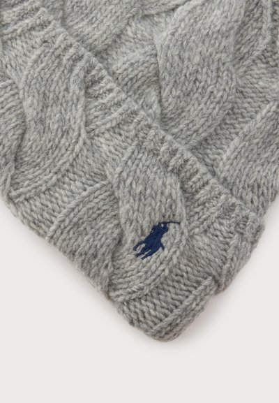 Tissu en laine grise tricotée avec un motif torsadé et un petit logo brodé bleu marine d’un cheval et de son cavalier.