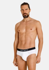 Slip bianchi con una vita elastica nera e il branding "camano". Tessuto liscio, vestibilità aderente e design classico degli slip.
