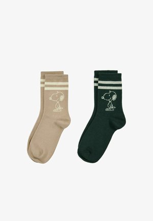 Deux paires de chaussettes mi-mollet, une beige et une vert foncé, chacune avec deux bandes blanches et un motif du personnage Snoopy près du haut.