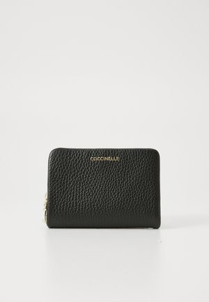 Carteira preta de couro texturizado com logotipo dourado, apresentando um fecho de zip e uma forma retangular slim. Interior suave com compartimentos.