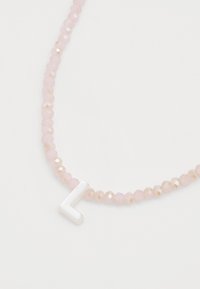 Rosa fasetterte perler danner et smykke med en hvit bokstav "L" anheng, som viser en jevn tekstur og et enkelt design.