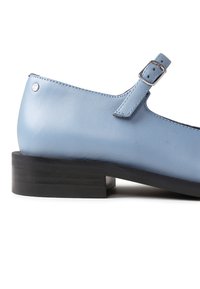 Hellblaue Lederschuhe mit runder Spitze, Riemen mit Schnalle und niedrigem schwarzen Holzabsatz. Glatte Textur und schlichtes Design.
