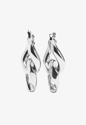 Srebrne kolczyki o skręconym wzorze, posiadające gładkie, odbijające światło powierzchnie oraz bezpieczne zapięcie u góry. Unikalny, pleciony kształt i faktura.