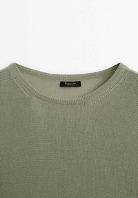 Pull en tricot vert olive clair avec un col rond et une petite étiquette de marque noire à l'intérieur du col.