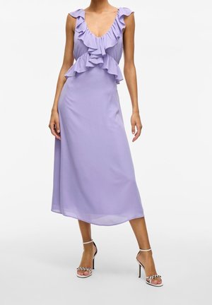 Levandulové midi šaty s volánkovým výstřihem a rukávy, hladká látka, pouzdrový pas a rozšířený spodní lem; doplněné černobílými sandály na vysokém podpatku.