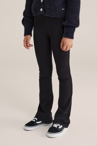 Fekete, bővülő leggings nyújtható anyagból, fekete sportcipővel, fehér részletekkel párosítva. Puha tapintás, karcsú fazon és laza stílus.