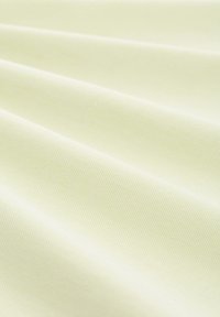 Ljust gult tyg med en slät textur, med subtila diagonala linjer som skapar ett vävt mönster. Mjukt och lättflödig design.