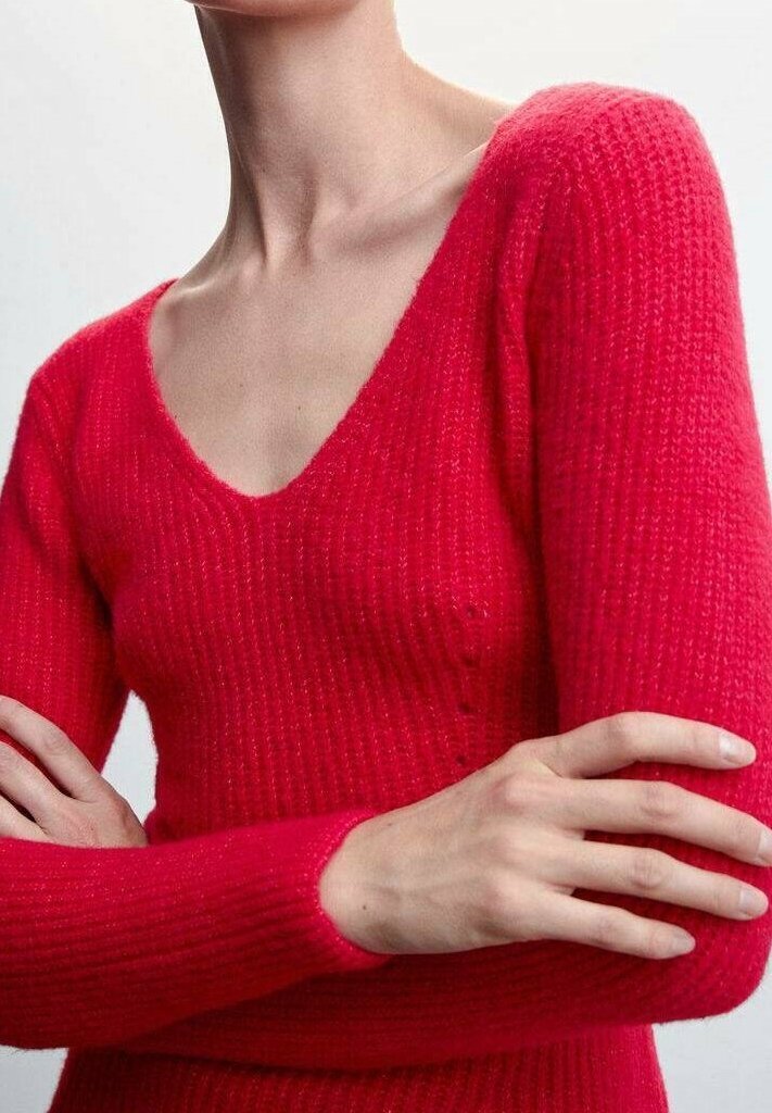 Personne portant un pull en tricot côtelé rouge vif à manches longues avec col en V, les bras croisés, montrant le cou et le haut de la poitrine.