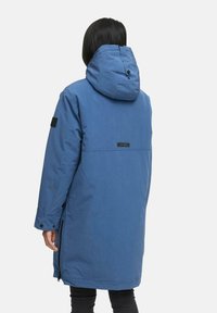 Parka isolante bleue avec capuche, dotée d'une fermeture éclair à l'avant, de poches latérales et d'un patch logo au dos. Texture lisse, longueur longue.