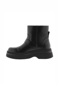 Botas negras hasta el tobillo de material sintético con una suela gruesa y estriada y una correa ancha en la parte media del pie. Acabado suave, diseño minimalista.