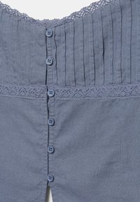Vêtement en tissu bleu avec des plis verticaux, une bordure en dentelle près du haut et du milieu, et une rangée de six boutons bleus assortis au centre.