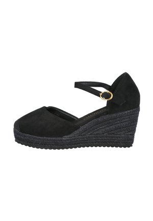 Zapato de cuña negro con punta cerrada, correa en el tobillo, hebilla dorada y suela con plataforma texturizada.