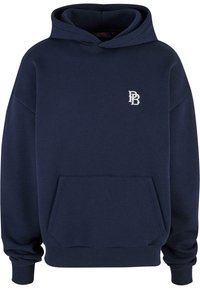 Námornícké modré mikina s predným vreckom, kapucňou na šnúrku a bielou vyšitou logom "PB" na hrudi. Vyrobené z mäkkej a odolnej tkaniny.