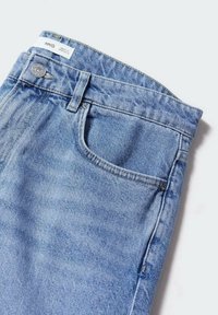 Jeans in denim azzurro chiaro con tasca frontale, cuciture visibili e chiusura con bottone in metallo. La vita presenta un'etichetta del marchio.