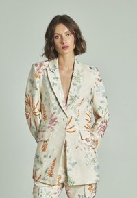 Blazer de lino con bordado floral colorido en tonos de verde, rosa, naranja y azul, con solapa en pico y bolsillos delanteros.