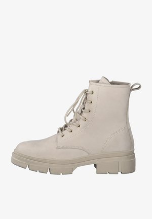 Botines beige de ante, con puntera redonda, seis ojetes y una suela de goma gruesa con textura rugosa y una lengüeta en la parte posterior.
