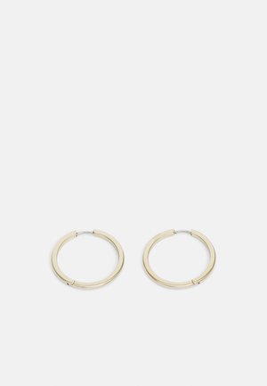 Boucles d'oreilles créoles en métal doré avec une finition lisse et polie, dotées d'une fermeture sécurisée et d'un design circulaire minimaliste.