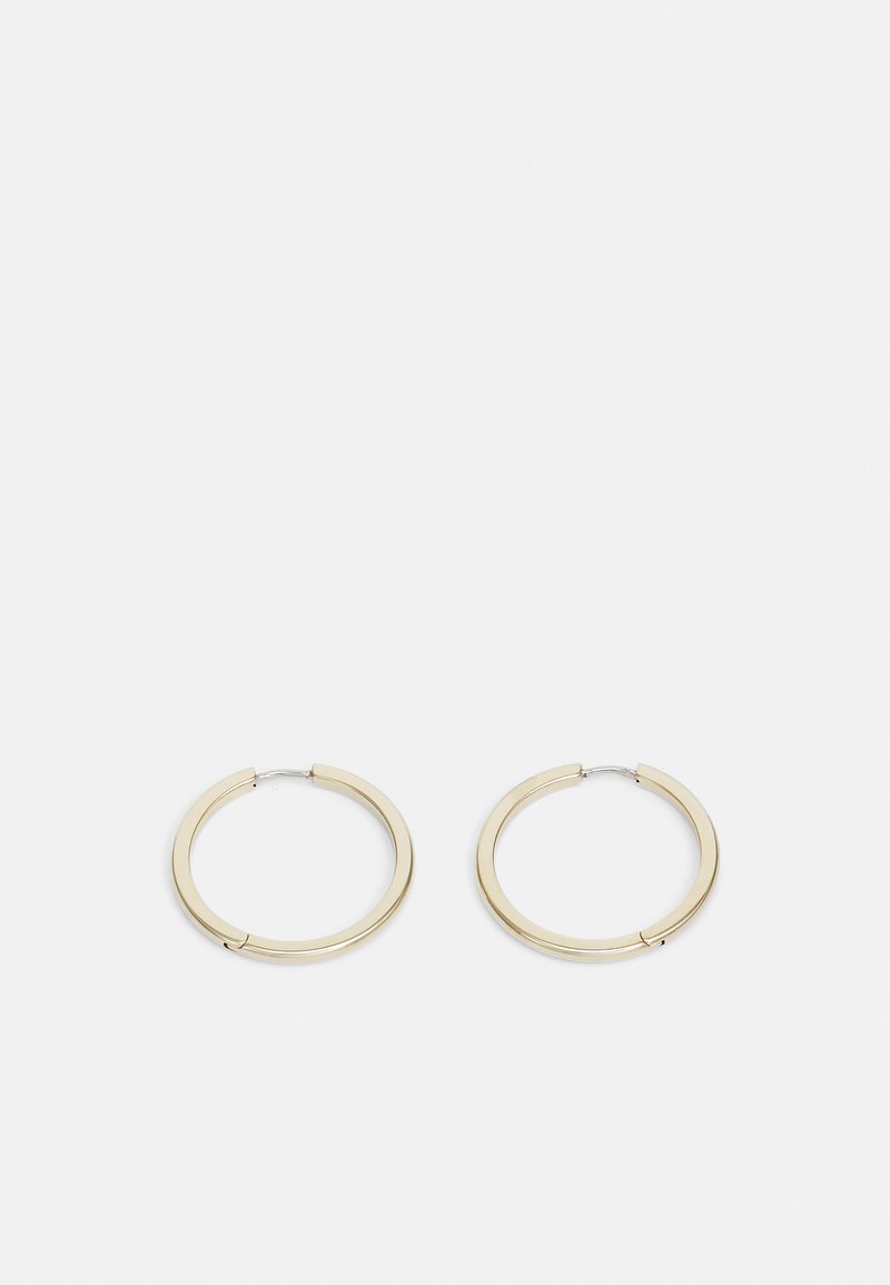 Goldfarbene Metall-Hoops mit einer glatten, polierten Oberfläche, ausgestattet mit einem sicheren Verschluss und einem minimalistischen, kreisförmigen Design.