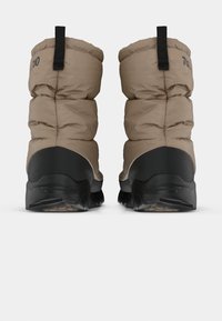 Bottes de cheville en tan avec une semelle en caoutchouc noir texturé, dotées d'une languette à l'arrière et de détails de couture sur un matériau supérieur lisse.