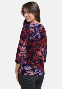 Marinefarbener Oberteil mit floraler Stickerei und Dreiviertelärmeln, verziert mit roten und lila Blättern, aus weichem Material und mit abgerundetem Saum.