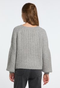 Pulover gri tricotat cu o textură canalată, mâneci late și decolteu rotund. Designul prezintă o croială lejeră și un material moale.