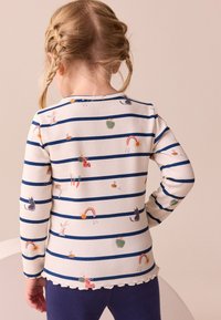 Langärmliges, geripptes Shirt mit blauen und weißen horizontalen Streifen, verziert mit bunten Tier- und Naturoptiken, Saum mit gewelltem Abschluss.