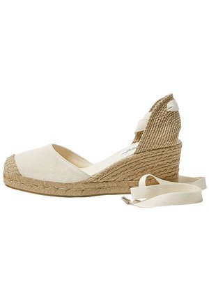 Espadrille compensée en toile beige avec talon en jute tissé et brides autour de la cheville. Tissu texturé et détail tressé, avec un bout rond et une semelle plate.