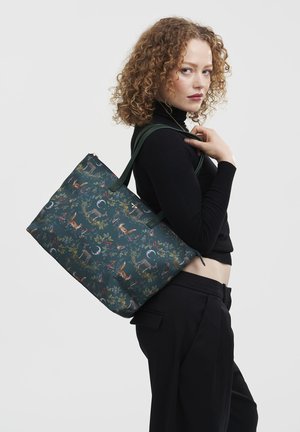 Reusable tote bag in dark green fabric, featuring a wildlife pattern with animals and flowers, sturdy handles, and a zip closure.