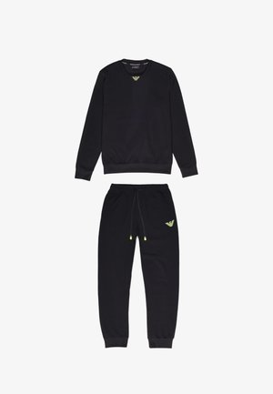 Felpa nera e joggers coordinati in tessuto morbido. Presenta accenti gialli del logo sul petto e sulla coscia, polsini elasticizzati e coulisse regolabile.