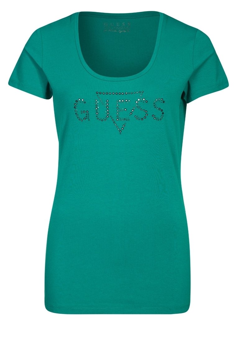 Camiseta de mujer en teal con mangas cortas y escote redondeado. Presenta la palabra "GUESS" en rhinestones en el pecho. Material de algodón suave.
