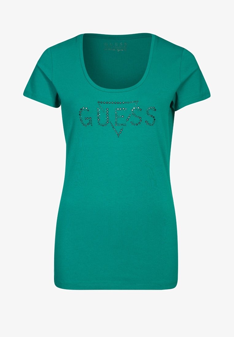 Camiseta de mujer en teal con mangas cortas y escote redondeado. Presenta la palabra "GUESS" en rhinestones en el pecho. Material de algodón suave.