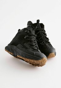 Czarne buty trekkingowe o ruggedowym designie, z teksturowaną cholewką, wyściółką kołnierza i gumową podeszwą dla lepszej przyczepności.