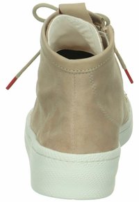 Beige semišové vysoké tenisky s bílou gumovou podrážkou, zaoblenou špičkou a červeným akcentem u utahování šňůrek.