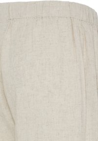 Pantalon en tissu de lin beige avec taille élastique et poches latérales, montrant en gros plan la texture et les détails de couture.