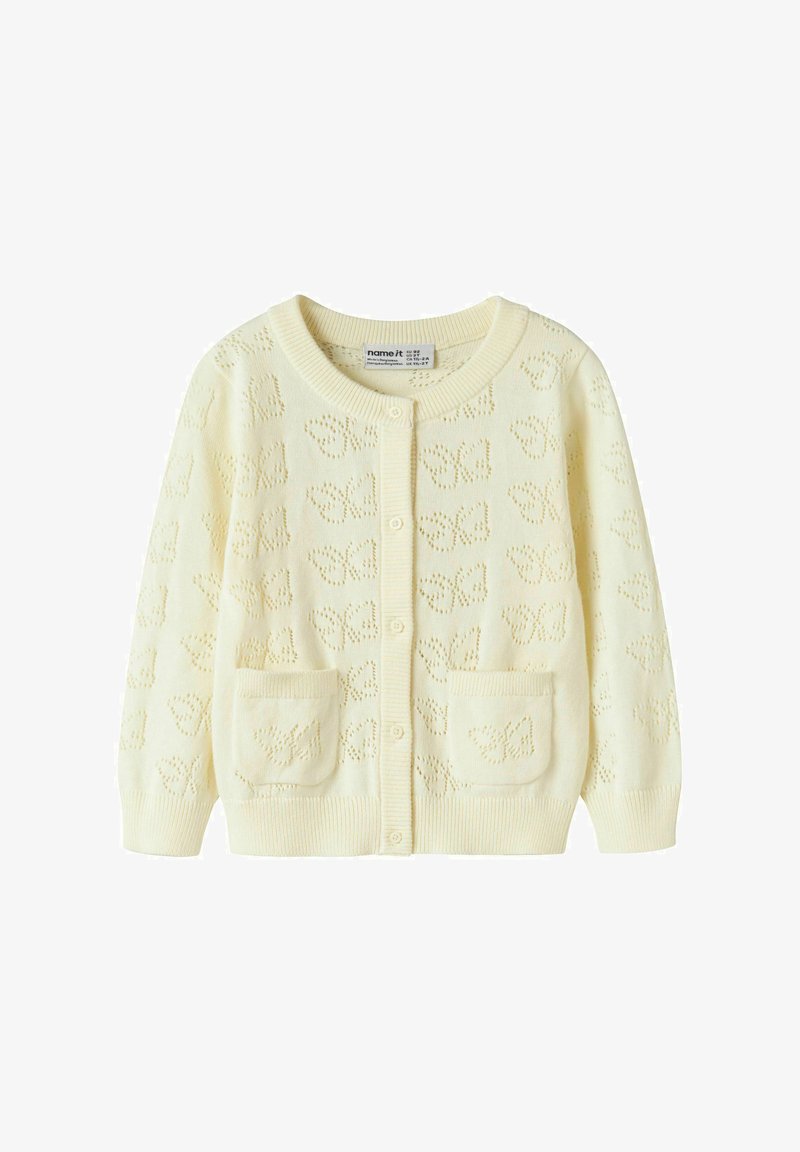 Kreemikas kootud kardigan liblikamustritega, ees nupud, soonikkoes mansetid ja alläär, ning kaks esist taskut liblikakujundustega.