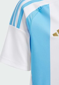 Camiseta de fútbol para hombres con rayas verticales en azul claro y blanco, confeccionada en tejido transpirable, con una textura sutil y un acento de logotipo en dorado.