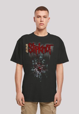Black oversized t-shirt with a graphic print featuring a red splatter and a cracked glass effect, accented with white and red "Slipknot" text.