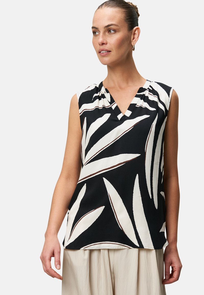 Top senza maniche di colore nero con un motivo a foglie bianco e marrone, design a V, tessuto morbido e vestibilità rilassata, con dettagli di pieghe sottili.
