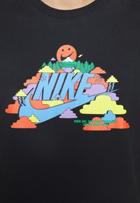 Černé bavlněné tričko s barevným grafickým designem, který zobrazuje stylizované mraky, stromy, slunce a výrazné modré logo Nike.