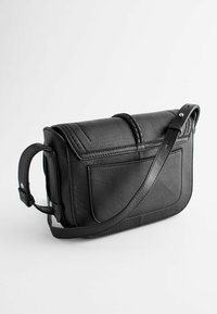 Černá kožená crossbody taška s texturovaným povrchem, pleteným detailem a nastavitelným popruhem; má přední kapsu a strukturovaný design.